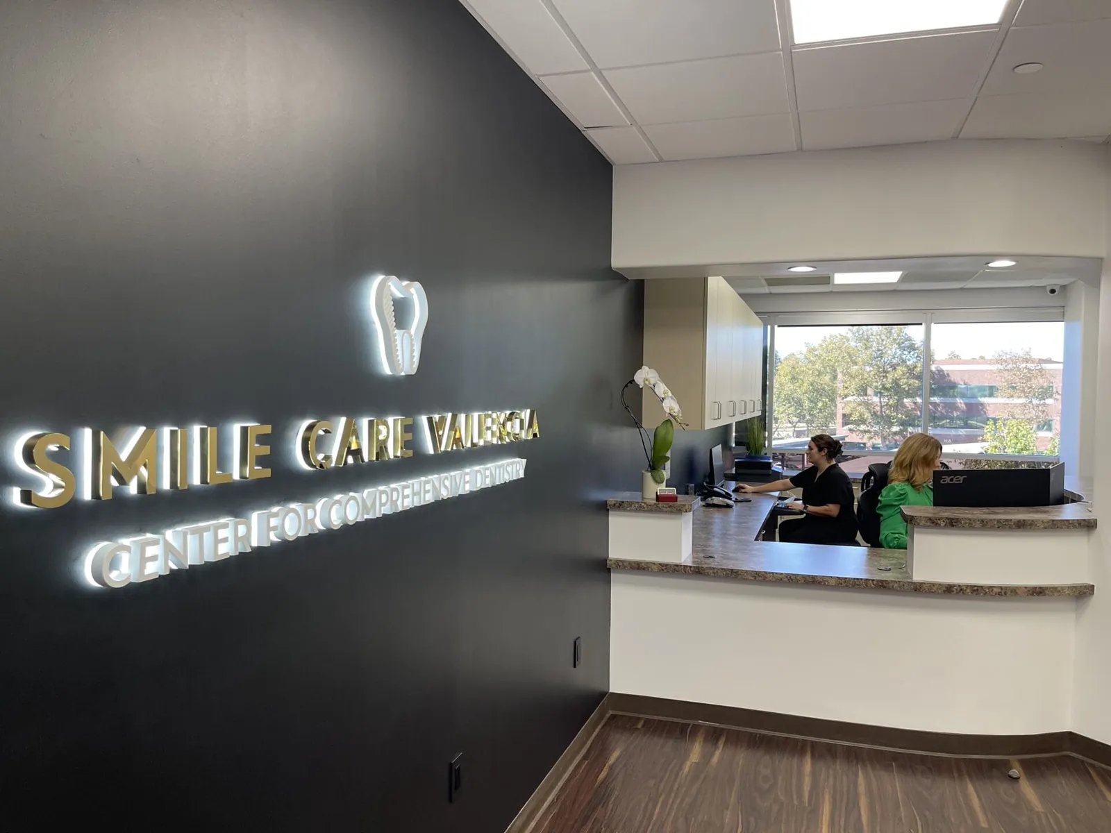 Dentist office reception with two staff members.