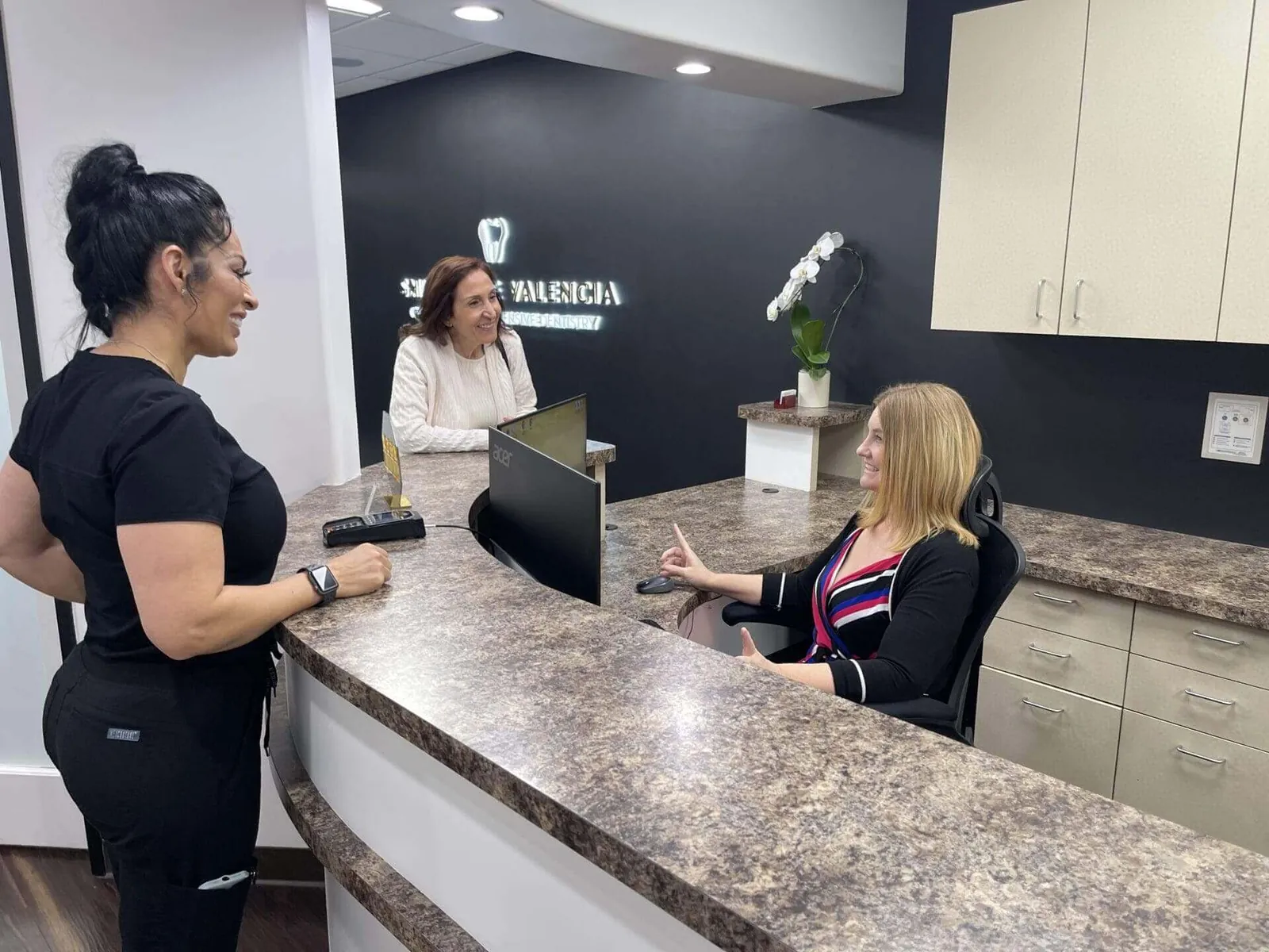Women at the dental office reception desk.