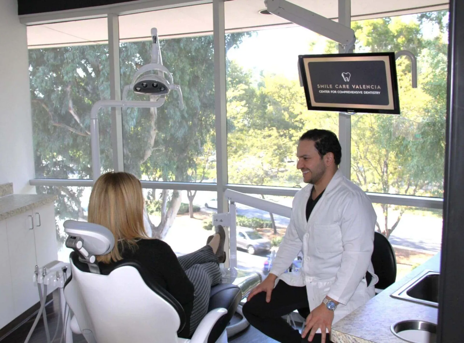 Dentist talking to patient at Smile Care Valencia.