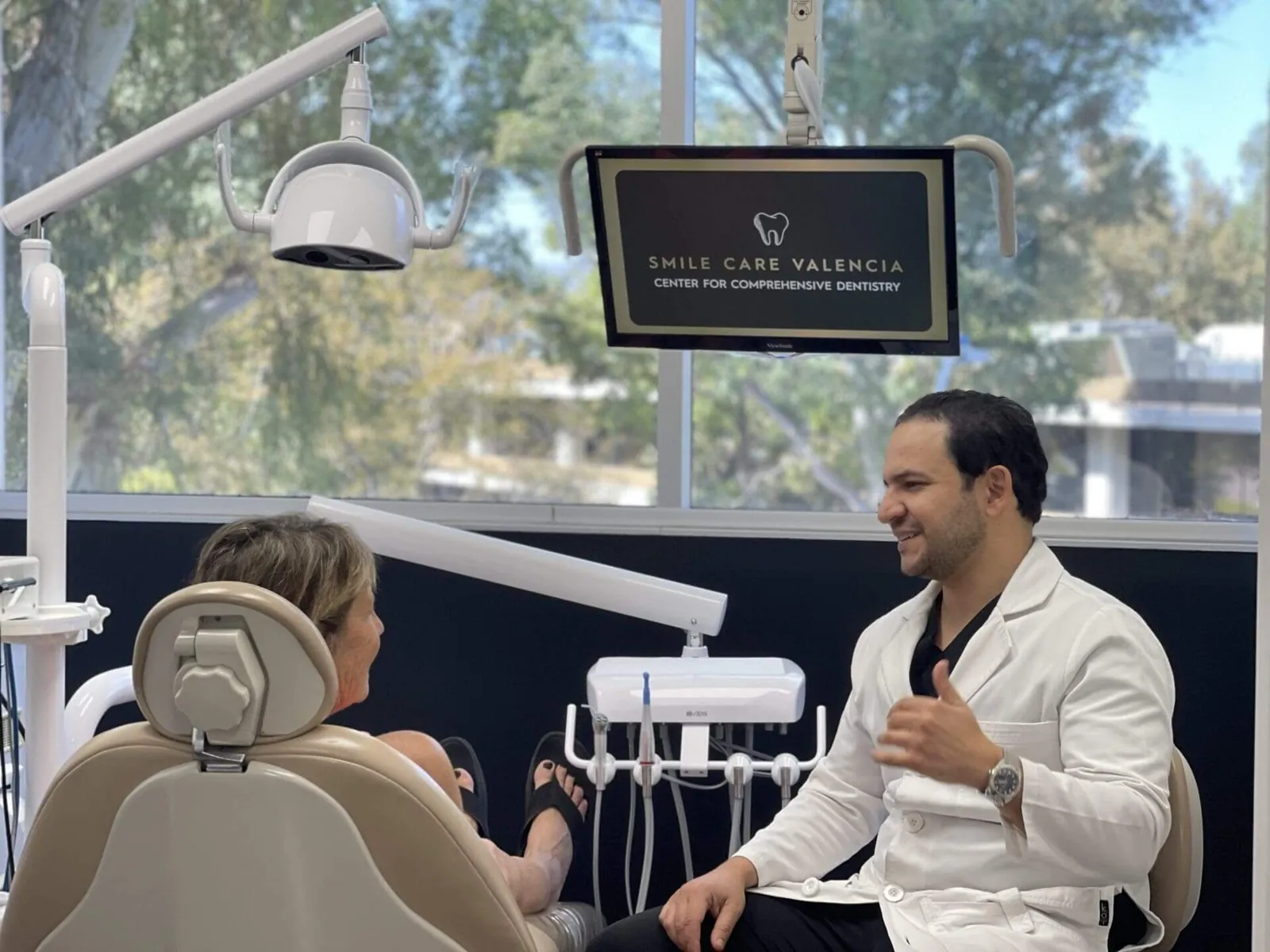 Dentist talking to patient at Smile Care Valencia.