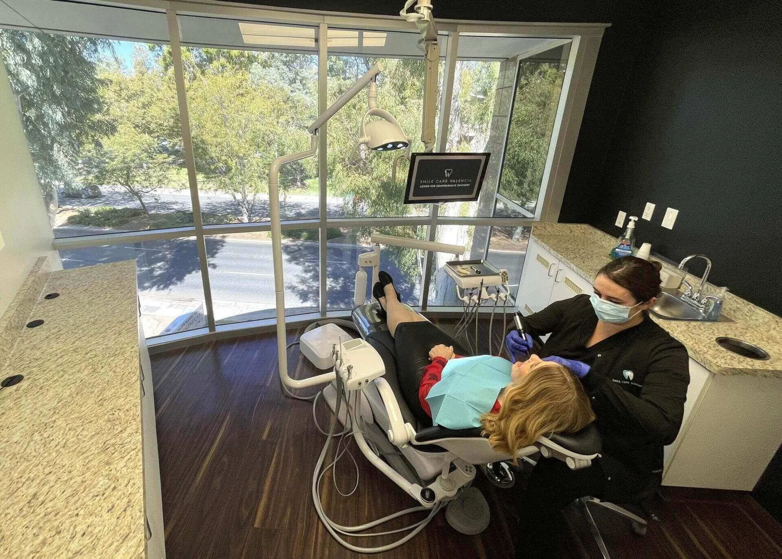 Dentist working on patient in chair.